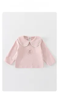 Vue détaillée du haut pour bébé en coton rose avec col Peter Pan en dentelle et motif ours
