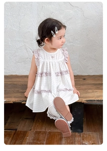 Détail de robe d'été fleurie pour fille avec dentelle violette et jupe en coton à volants