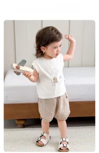 Detail of baby summer outfit featuring cotton sleeveless vest and plaid shorts