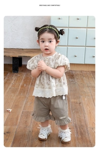 Detail of floral puff sleeve top with Chinese frog button and ruffled khaki shorts set
