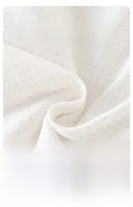 Dettaglio del tessuto in cotone per neonati con pois grigi e morbida trama a maglia