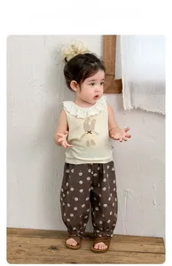 Detail of baby girl summer outfit featuring lace collar bunny top and floral bloomers