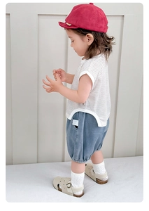 Detailed view of baby boy summer outfit with striped t-shirt and denim shorts