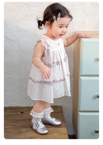 Détail d'une robe en coton pour filles avec volants violets et chaussettes en dentelle