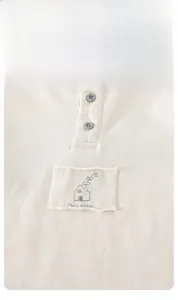 Detail of baby cotton knit Henley top with rib texture and small house embroidery