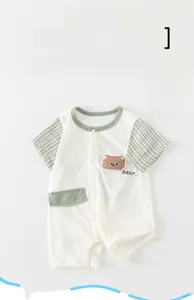 Detail of baby short sleeve romper with cartoon bear patch and green plaid trim