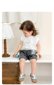 Dettaglio set estivo neonato con gilet in cotone e pantaloncini in denim per bambini
