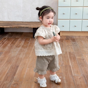 Girl summer floral blouse and khaki shorts two-piece set in a warm home setting