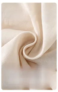 Detailed macro view of soft, breathable off-white cotton knit fabric for baby rompers