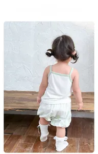 Detail view of the back of a girl summer set with white tank top and green floral shorts
