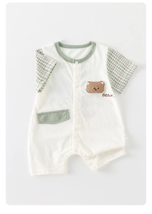Detailed view of the snap buttons and brown bear patch on the white baby romper