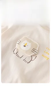 Détail du patch lion 3D et de la broderie sur le body pour bébé en coton beige chaud
