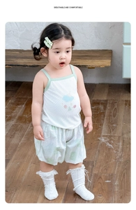 Detail of baby girl summer set featuring white cloud tank top and green checkered shorts