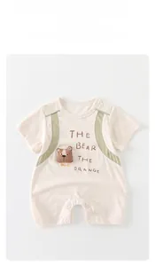 Detail of baby cotton romper featuring 3D bear patch and snap buttons on white background