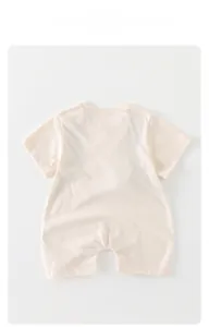 Flat lay of soft beige short-sleeve cotton baby romper with a minimalist round neckline