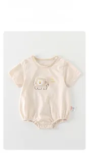 Détail d'un body bébé en coton à manches courtes avec motif lion et boutons pression