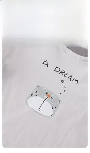 Détail d'un t-shirt en coton pour bébé avec visage de dessin animé et texte A DREAM