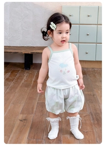 Close-up of baby girl's white ribbed tank top and green checkered bloomers set