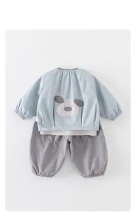 Détail d'un ensemble bébé garçon avec broderie chien de dessin animé sur sweat-shirt bleu