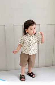 Dettaglio completo completo neonato con camicia beige stampa orso e pantaloncini marroni