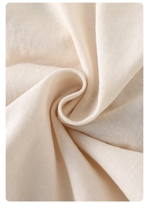 Detailed view of soft beige knitted cotton fabric showing fine texture and premium softness