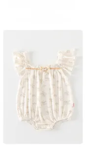 Détail d'un body floral pour bébé avec manches volantées et nœud en perles