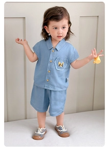 Dettaglio del set in denim azzurro per bambino con ricamo a forma di cane sulla tasca