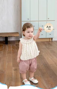 Detaillierte Nahaufnahme von geblümtem Baumwolltop und rosa Puffhose für Kleinkinder