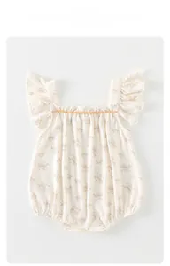 Détail du barboteuse bébé fille avec imprimé fleuri, dentelle orange et volants