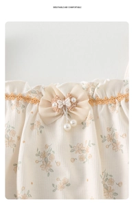 Détail du body bébé floral avec col en dentelle et accessoire nœud en mousseline fine