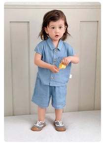 Dettagli camicia estiva in cotone azzurro con bottoni in legno e taschino per bambini