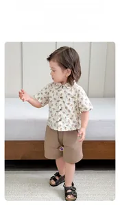 Dettaglio del set estivo da bambino con camicia a motivi di orsi e pantaloncini marroni