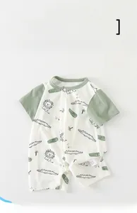 Detail of baby romper with lion and crocodile prints and wild free text on cotton fabric