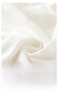 Gros plan sur le tissu jacquard blanc respirant avec texture diamantée douce du barboteuse