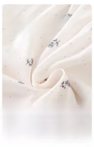 Detailaufnahme von weichem, atmungsaktivem Baumwollstoff mit blauem Blumenmuster für Babys