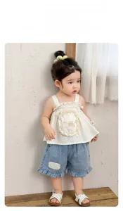 Detail of floral strap top with bear print and ruffle denim shorts on toddler girl