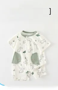 Close-up of baby romper showing dinosaur print and convenient snap buttons on soft cotton