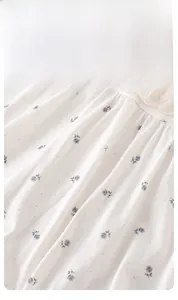 Detail eines Babybodys mit Blumenmuster aus weicher Baumwolle und Vintage-Spitzenkragen