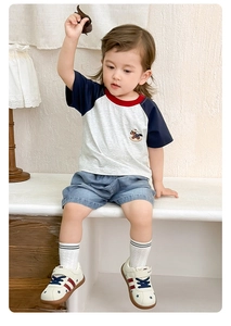Detail of baby boy cotton t-shirt with horse embroidery and washed denim shorts