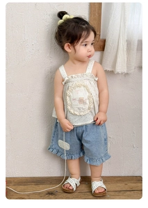 Close-up of floral camisole with bear embroidery and ruffle denim shorts for girls