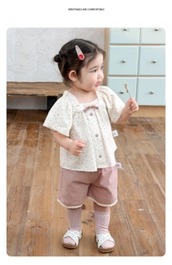 Detailaufnahme von Mädchen Beige Blumenshirt und rosa Spitzenshorts Set