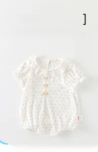 Détail d'un body bébé classe A à fleurs avec col à volants et petits nœuds jaunes