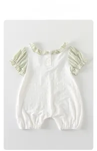 Détail de barboteuse d'été pour bébé en coton blanc texturé avec col à volants verts