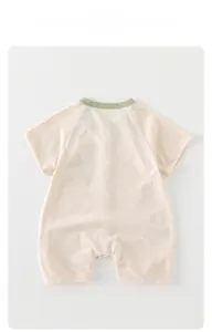Close-up of baby short sleeve cotton romper with green trim neckline and breathable fabric