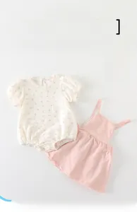Detail of baby floral romper and pink suspender skirt with breathable textured fabric