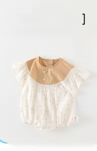 Detail of floral baby romper with lace sleeve cuffs and decorative buttons