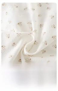 Gros plan du tissu en coton floral doux montrant la texture respirante et l'épaisseur