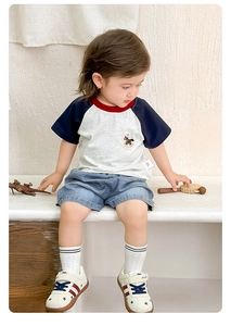 Detail of baby boy cotton t-shirt with horse embroidery and washed denim shorts set