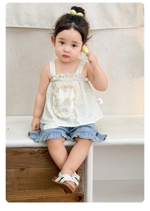 Detail of floral spaghetti strap top and denim shorts set worn by a toddler girl