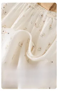 Breathable baby bodysuit fabric detail with floral rabbit print and lace trim texture